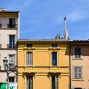 Historic pastel-colored buildings under blue sky in Aix-en-Provence, France.